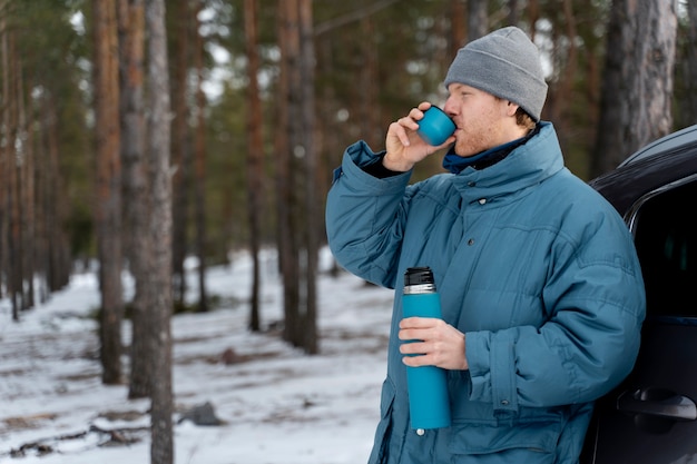 Free photo close up on man enjoying hot drink while on winter trip