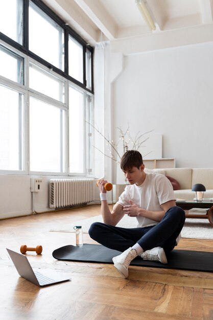 Close up on man exercising after online instructor