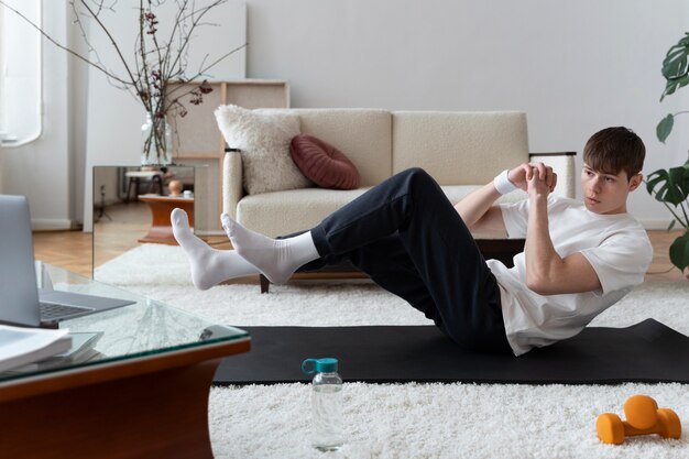 Close up on man exercising after online instructor