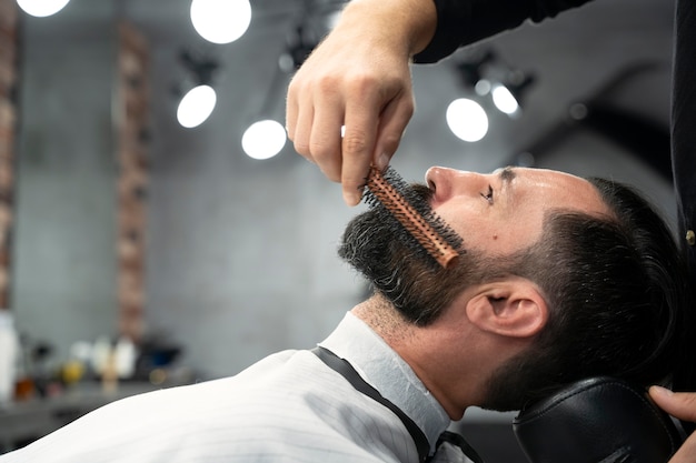 Close up man getting his beard groomed