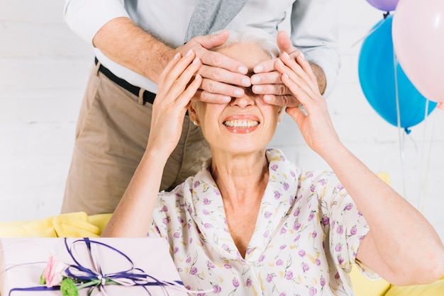 Free photo close-up of man giving surprise gift to her happy wife