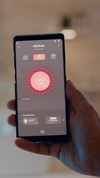 Free photo close up of man hand holding phone with modern software controlling lights