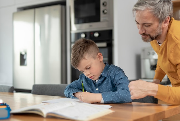 Close up man helping kid with homework