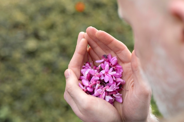 Free photo close up man holding beautiful flowers