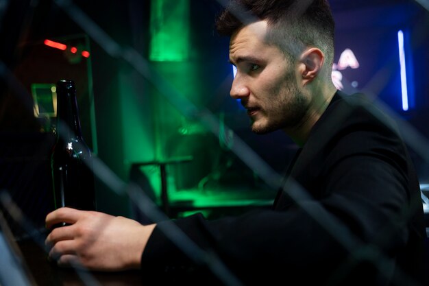 Close up man holding bottle at bar