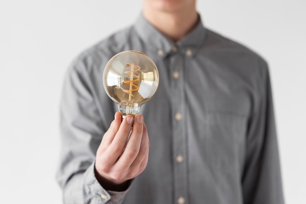 Free photo close up man holding bulb