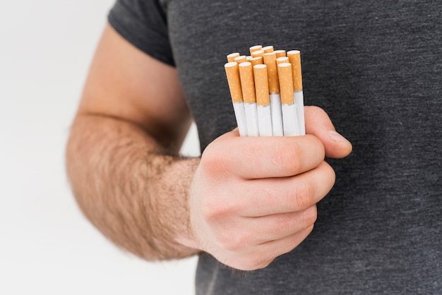 Free photo close-up of a man holding bundle of cigarette isolated on white background