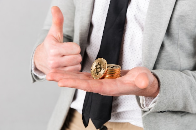 Close up of man holding stack of golden bitcoins