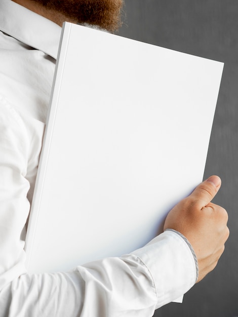 Free Photo close-up man holding a stack of paper mock-up