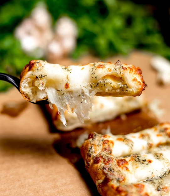 Free Photo close up of man holds a piece of turkish pastry stuffed with cheese