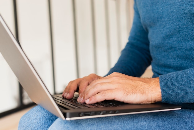 Free photo close-up man at home working on laptop