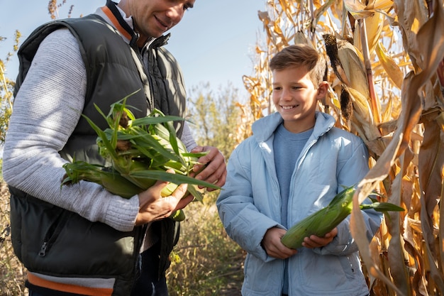 Free photo close up man and kid holding corn