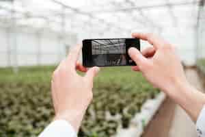 Free photo close up of man making photo of greenery