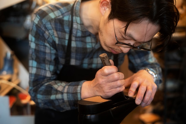 Free photo close up man making shoes