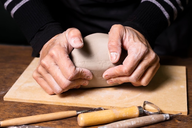 Free photo close-up man mixing clay