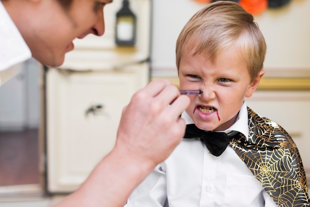 Free photo close-up man painting kid's face