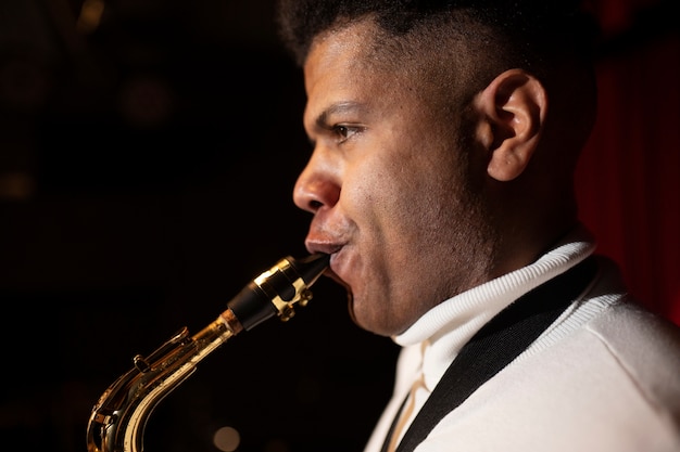 Free photo close up man playing the saxophone