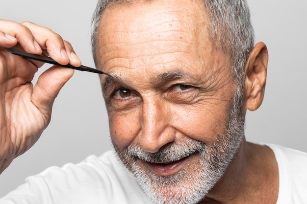 Close-up man plucking his eyebrow