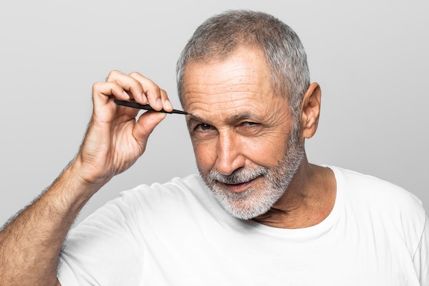 Close-up man plucking his eyebrows