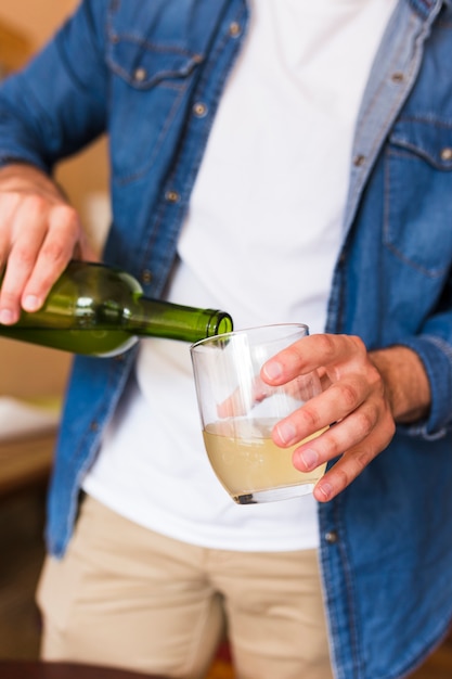 Close-up of a man pouring beer in glass