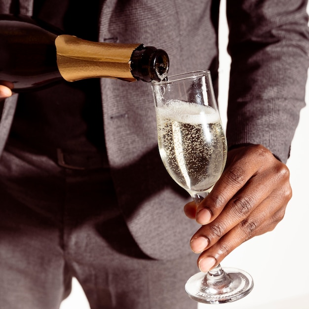 Free photo close-up man pouring champagne in bottle