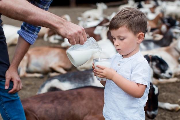 Free photo close-up man pouring milk to little boy