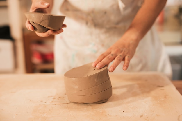 Free photo close-up of a man preparing the clay on wooden table