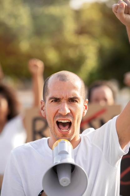 Close up man protesting with megaphone