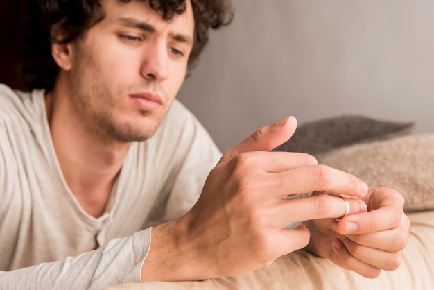 Close-up man pulling out wedding ring