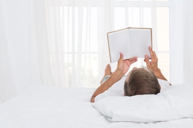 Close-up man reading in the bedroom