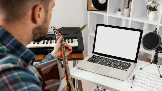 Close-up man recording a song with guitar