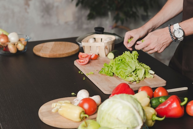 Close-up of man's hand cleaning lettuce on kitchen counter