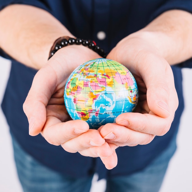 Free Photo close-up of a man's hand holding globe