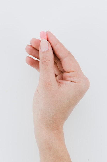 Close-up of man's hand holding pills over white background