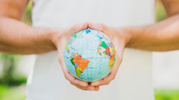 Free Photo close-up of man's hand holding small globe