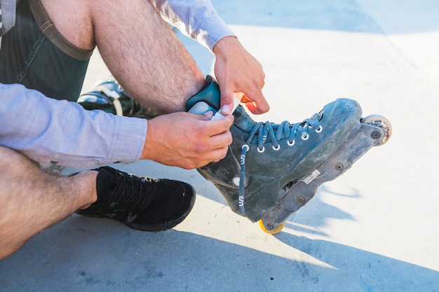 Free photo close-up of a man's hand putting on rollerskate