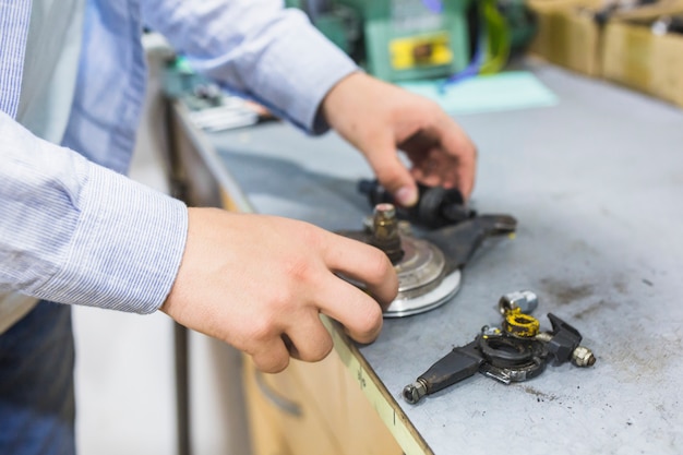 Free Photo close-up of a man's hand with bicycle parts in workshop