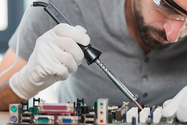 Free photo close-up of a man soldering computer circuit in workshop