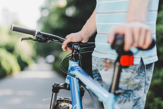 Close-up of a man standing with bicycle at outdoors