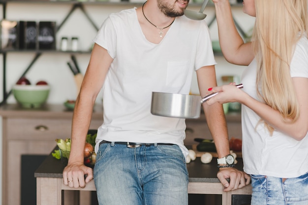 Free Photo close-up of man tasting the soup prepared by woman in the kitchen