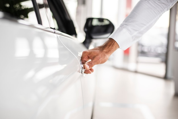 Close-up man testing car at dealership