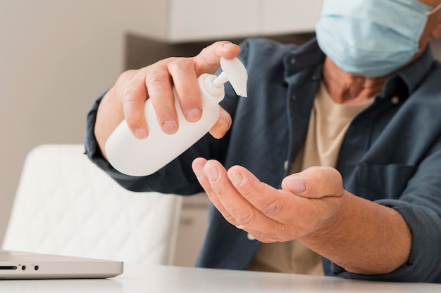 Free Photo close-up man using disinfectant