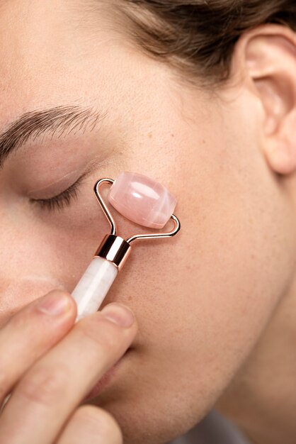 Close up man using gua sha tool