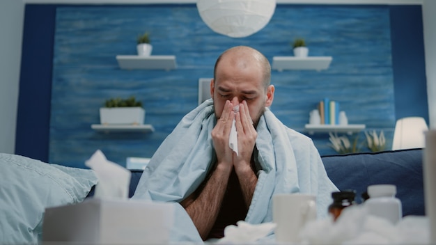 Free photo close up of man with cold and flu blowing runny nose