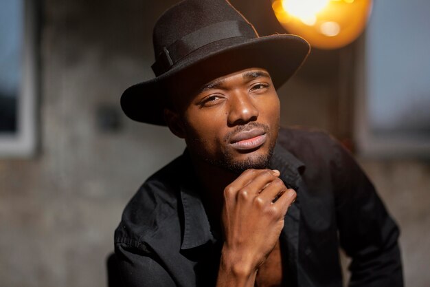 Close-up man with hat posing indoors