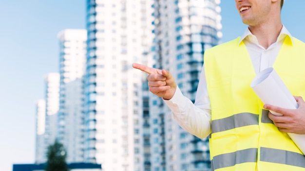 Free Photo close-up man with safety vest pointing at something