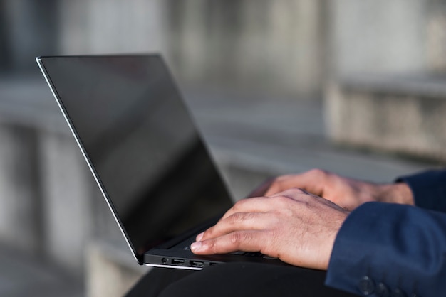 Close-up man working on laptop