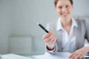 Free photo close-up of manager holding a pen with blurred background