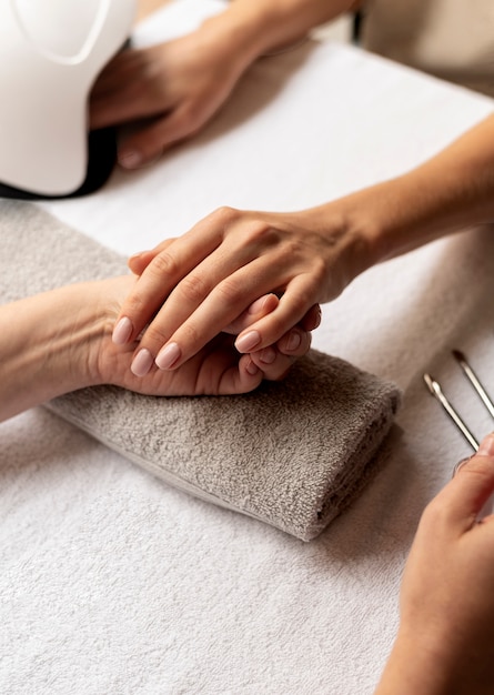 Close up manicurist holding nail tool