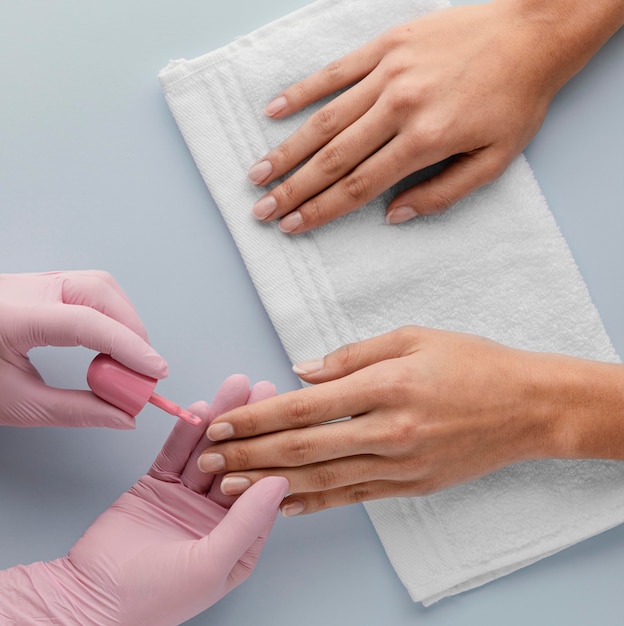 Close-up manicurist painting nails